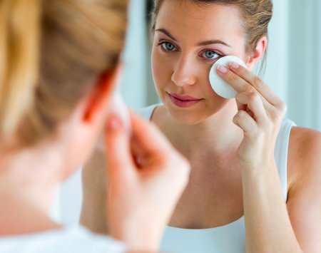 Mujer con maskné limpiando su rostro 